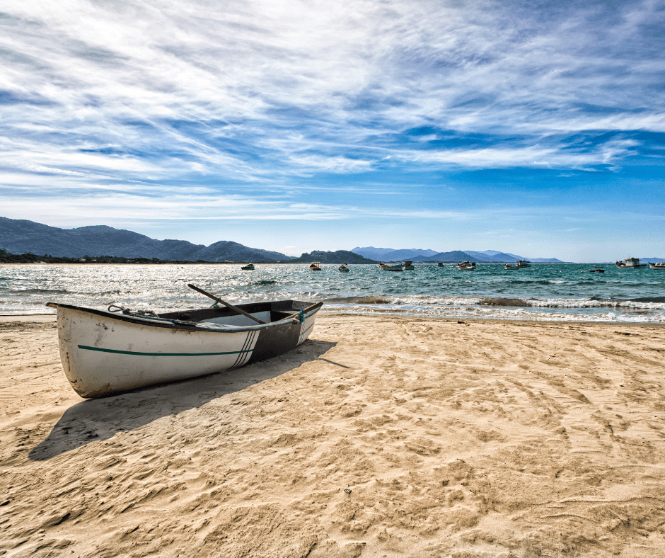 Blick vom Strand auf ein Boot und dahinter das Meer